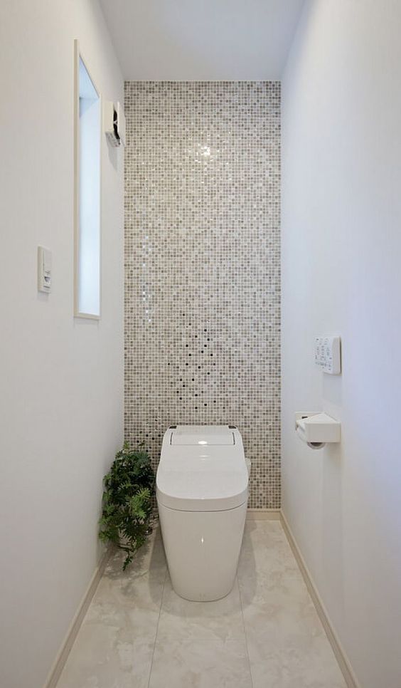 modern toilet met witte en badkamertegel muur